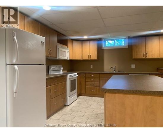 A kitchen with wooden cabinets and a white refrigerator.