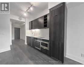A modern kitchen with dark wood cabinets and stainless steel appliances.