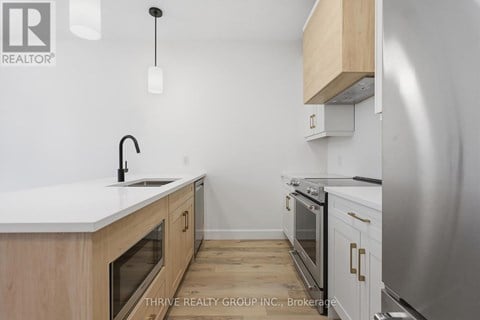 A kitchen with a white counter top and wooden cabinets.