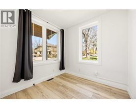 A room with a window showing a tree and a building outside.