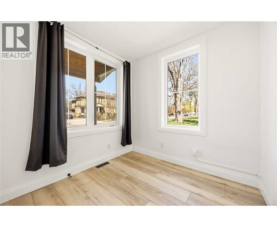 A room with a window showing a tree and a building outside.