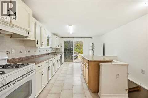 A kitchen with white cabinets and a white stove.