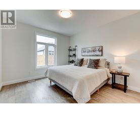 A bedroom with a bed, nightstand, and a window.