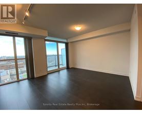 A large empty room with a view of the city through the windows.