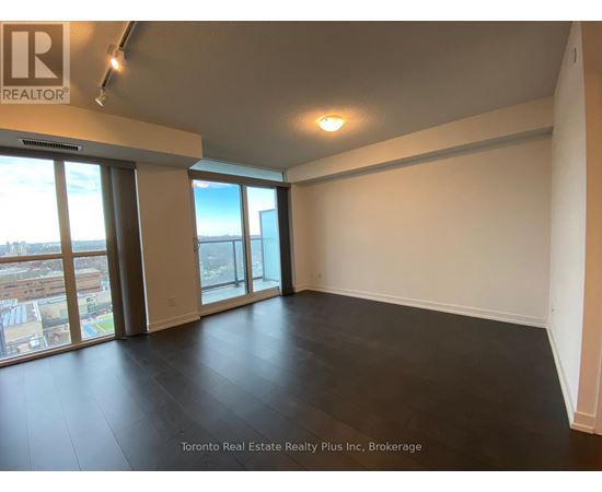 A large empty room with a view of the city through the windows.