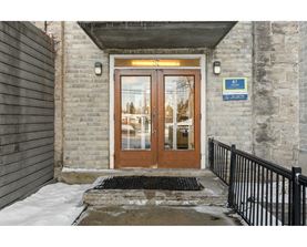 The entrance to a building with a brown door and a sign above it.