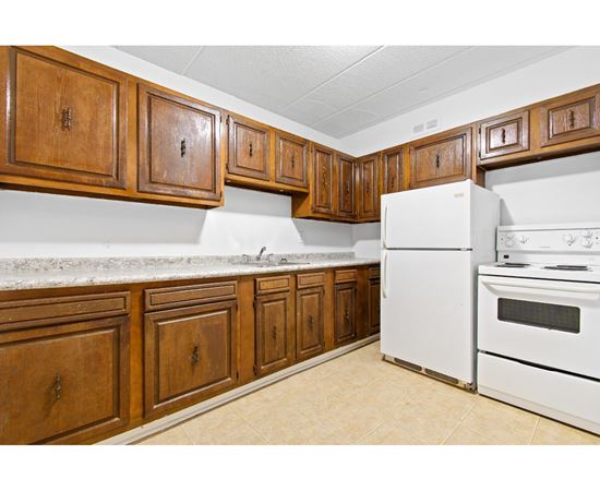 A kitchen with white appliances and wooden cabinets.