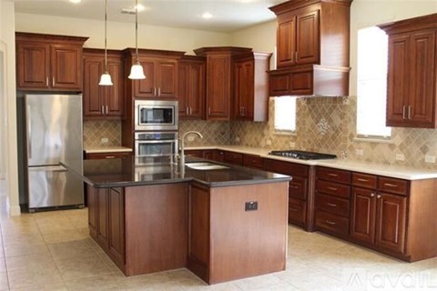 A kitchen with wooden cabinets and a stainless steel refrigerator.