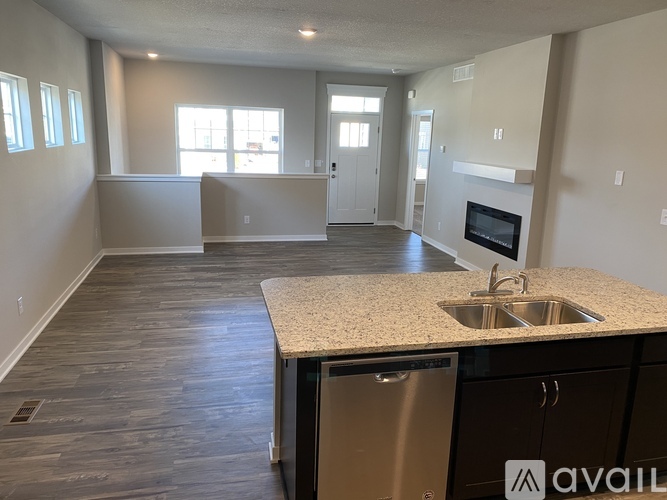 A kitchen with a sink, dishwasher, and a window.