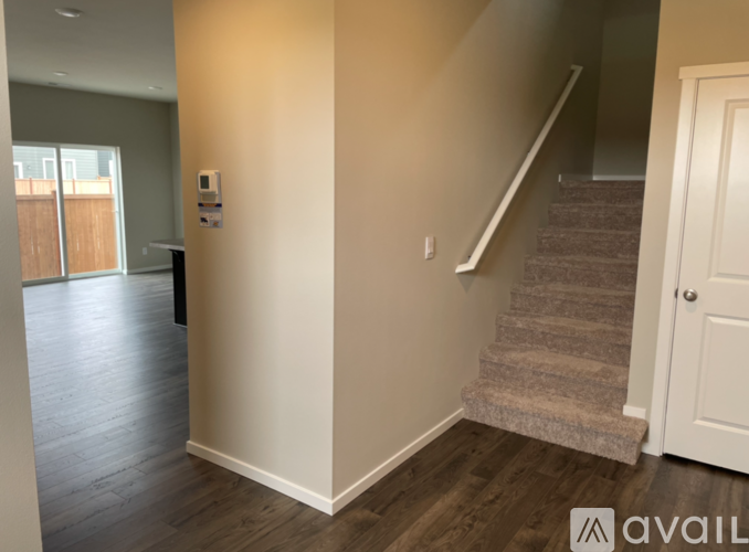 A hallway with a staircase and a door.