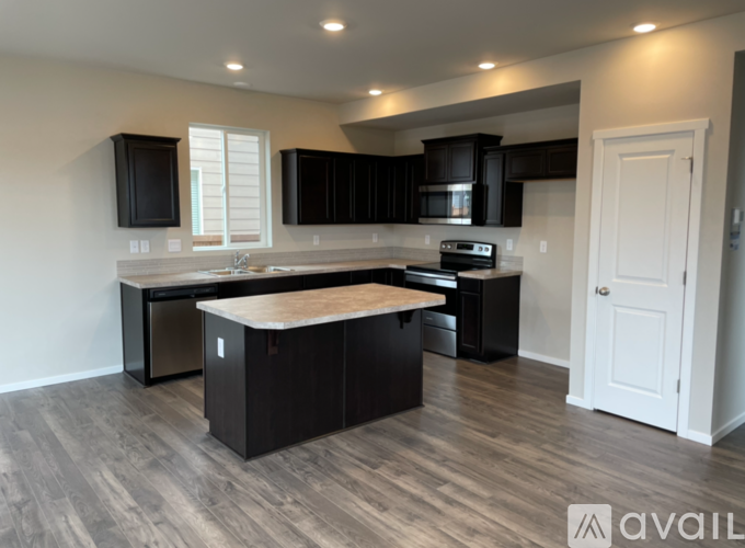 A kitchen with black cabinets and a wooden island.