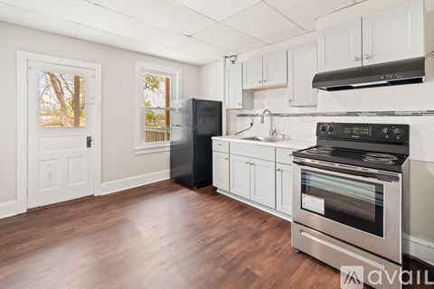 A kitchen with white cabinets and a stainless steel oven.