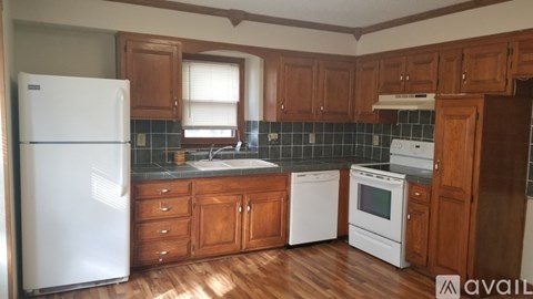 A kitchen with wooden cabinets and a white refrigerator.