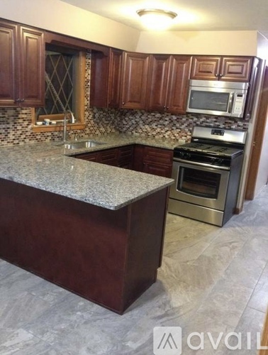 A kitchen with a granite countertop and stainless steel appliances.