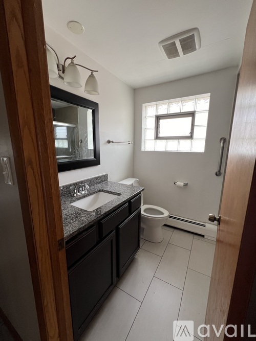 A bathroom with a sink, mirror, toilet and shower.