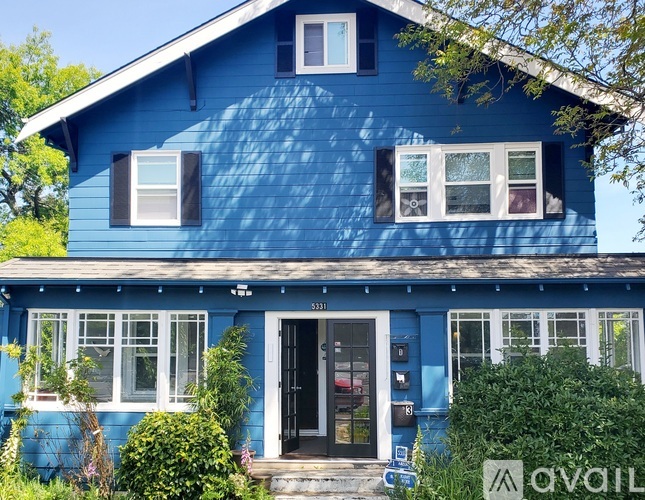 A blue house with a black door and windows.