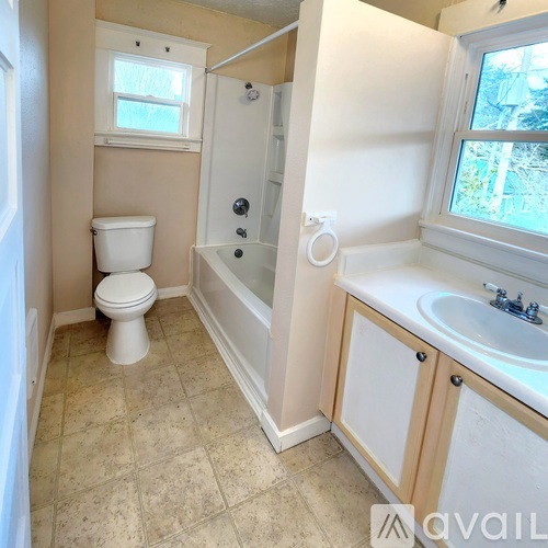 A small bathroom with a toilet, sink and bathtub.