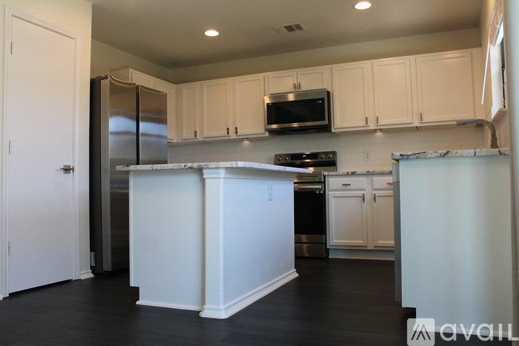 A kitchen with white cabinets and appliances.