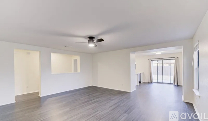 A spacious room with a ceiling fan and sliding glass doors.