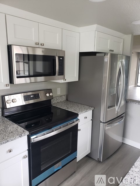 A kitchen with a stove top oven and a refrigerator.