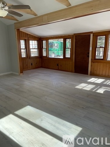 A room with wooden floors and a ceiling fan.