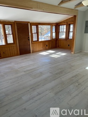 A room with wooden floors and a large window.