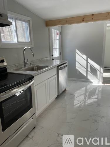 A kitchen with a black countertop and stainless steel appliances.