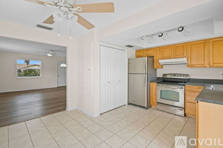 A kitchen with wooden cabinets and a ceiling fan.