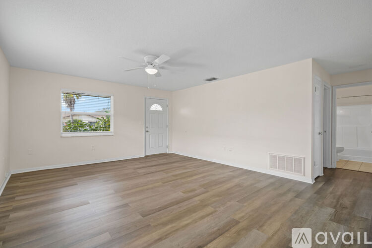 A room with wooden flooring and a ceiling fan.
