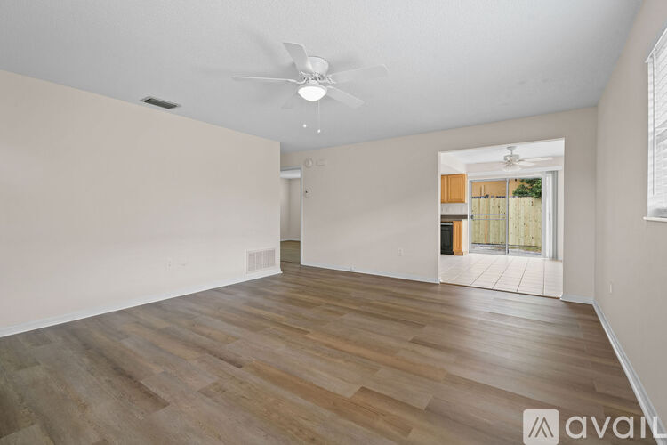 A room with wooden flooring and a ceiling fan.
