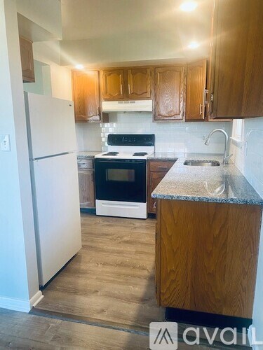 A kitchen with wooden cabinets and a white refrigerator.