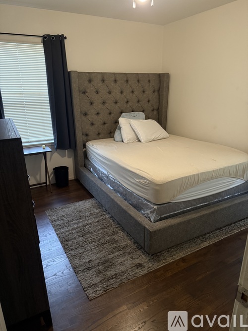 A bedroom with a large bed and a brown headboard.