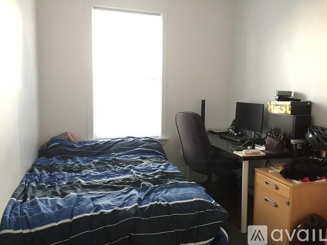 A bedroom with a bed, desk, and chair.