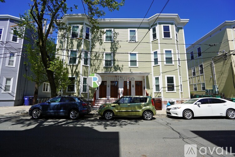 A street view of a building with cars parked in front.