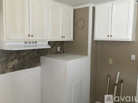 A kitchen with white cabinets and a marble countertop.
