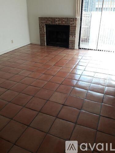 A room with a tile floor and a fireplace.