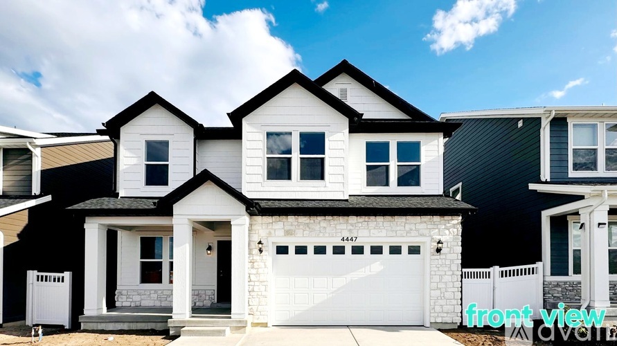 A white house with black trim and a black garage door.