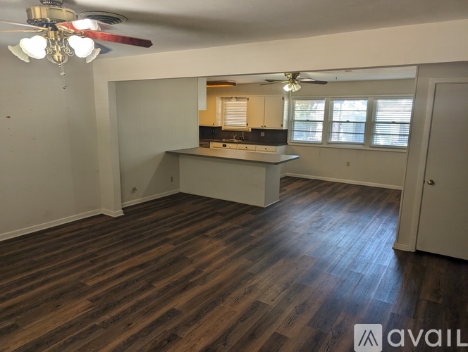 A room with a ceiling fan and wooden flooring.
