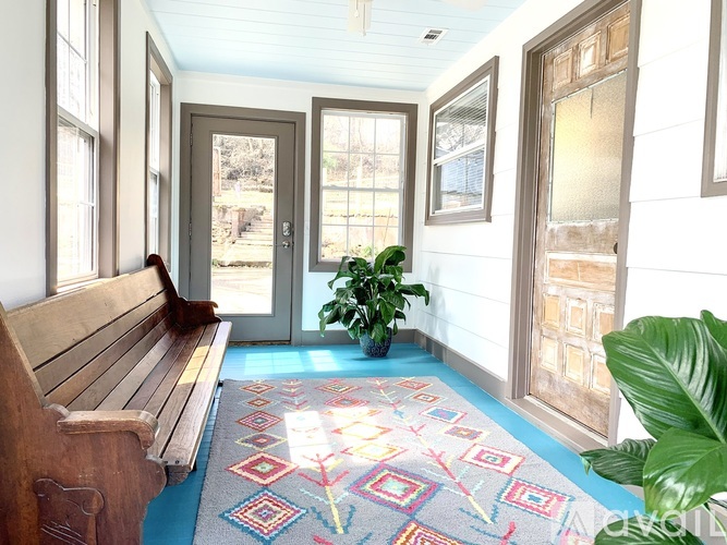 A wooden bench sits in front of a door with a glass window.