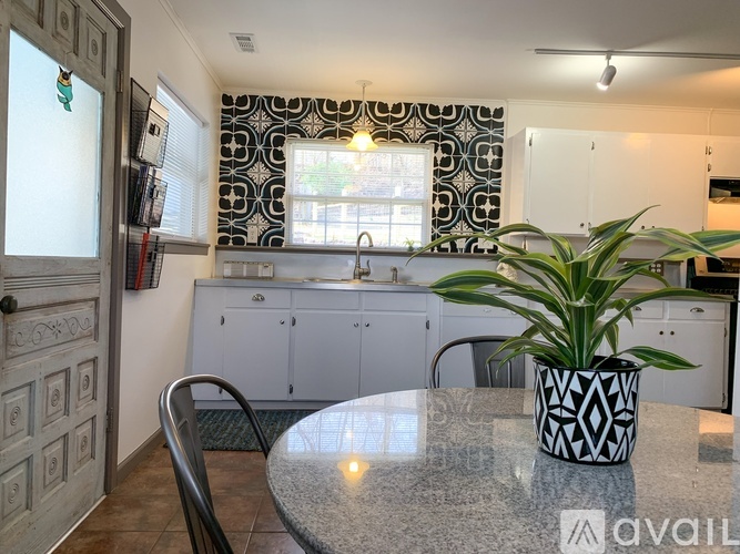 A kitchen with a table and chairs and a potted plant.