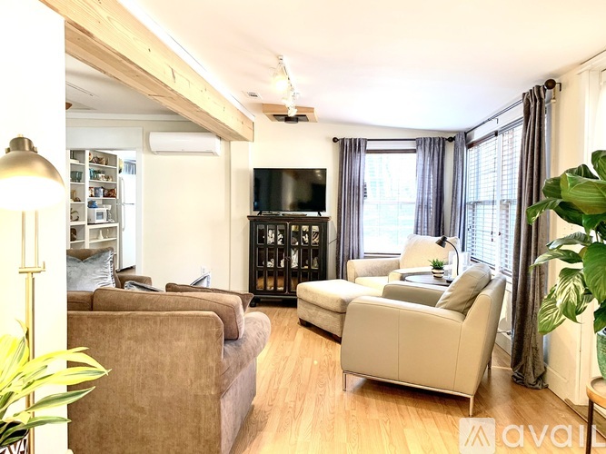A living room with a brown couch, a white couch, and a television.