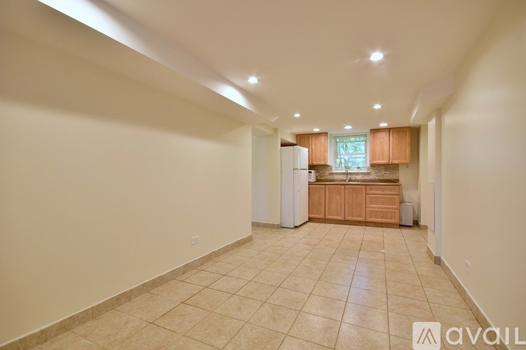 A spacious kitchen with wooden cabinets and a tiled floor.