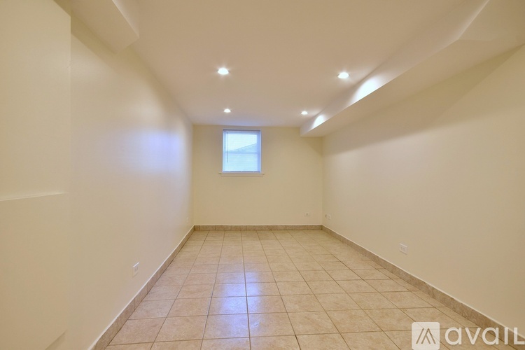 A spacious room with tiled flooring and a window.