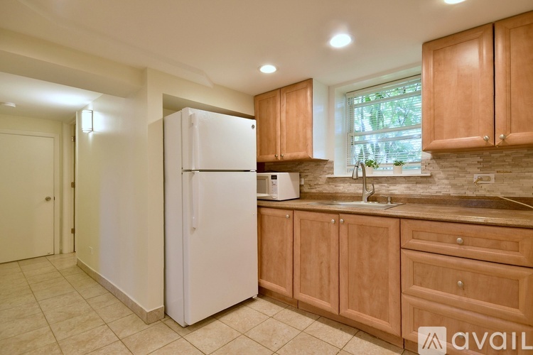 A kitchen with a white refrigerator and wooden cabinets.