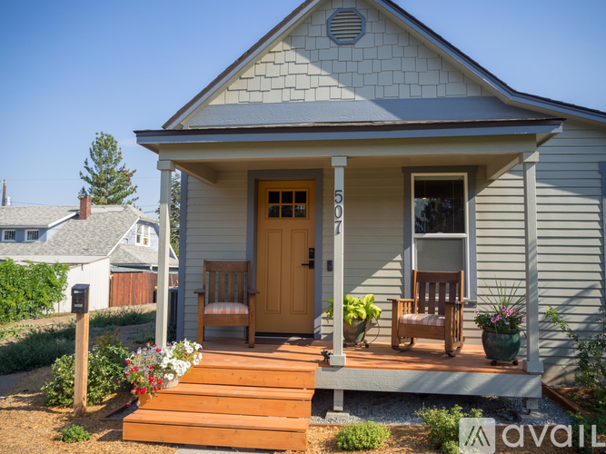 A small house with a wooden porch and a brown door.