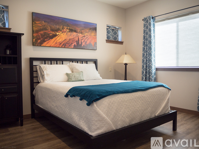 A bedroom with a large bed and a painting on the wall.