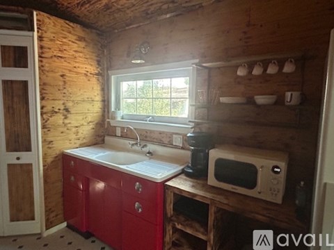 A small kitchen with a red cabinet and a white sink.