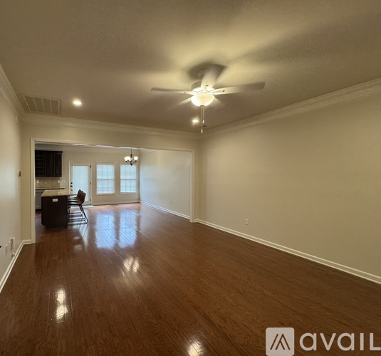 A spacious room with a ceiling fan and wooden flooring.