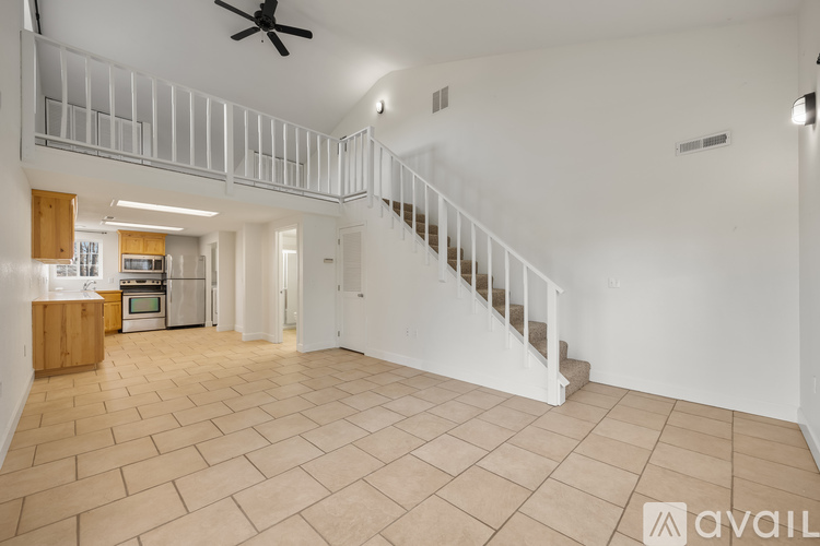 A spacious living room with a staircase leading to the upper floor.