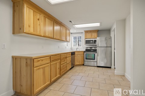 A kitchen with wooden cabinets and a tile floor.
